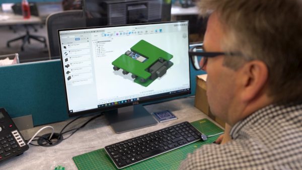 A man sitting at a computer create working on a CAD drawing
