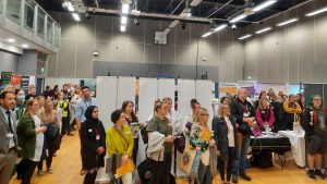 A crowd of people standing in the exhibition hall of Communication Works. 